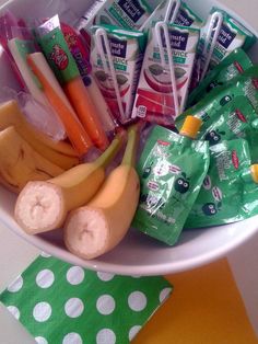 a bowl filled with fruit and snacks on top of a table