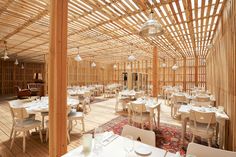 the inside of a restaurant with wooden walls and tables set up for an elegant meal