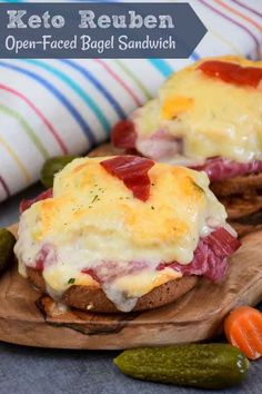 two open faced sandwiches with meat and cheese on them, sitting on a wooden board