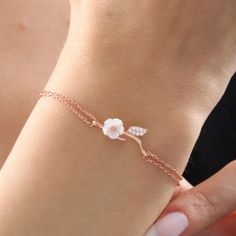 The magnolia-like flower on the bracelet is made of original mother-of-pearl stone. The mother-of-pearl stone represents power, grace and abundance. In addition, proximity to the mother-of-pearl stone has many benefits in energy. The two-stranded bracelet design that combines mother-of-pearl stone with the bracelet represents the journey of life and the elegance of women. It has a design that you will always carry with you in your daily life, on an important date, on the beach or at a great part Elegant Rose Gold Bracelets With Rose Design, Delicate Rose Gold Chain Bracelet Gift, Elegant Rose Gold Bracelet With Rose Design, Rose Gold Bracelet With Flower Charm As Gift, Rose Gold Bracelet With Rose Design For Gift, Delicate Sterling Silver Flower Bracelets, Delicate Sterling Silver Flower Bracelet, Dainty Silver Flower Bracelets, Delicate Flower-shaped Sterling Silver Bracelets