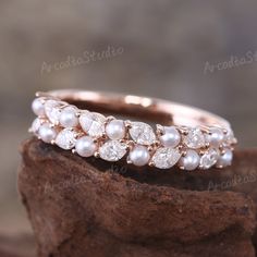 an image of a wedding ring on top of a piece of wood with pearls and diamonds