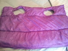 a purple purse sitting on top of a bed