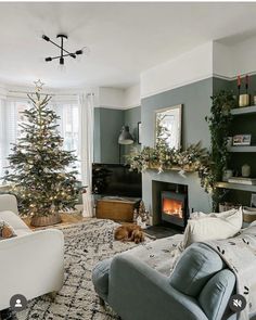 a living room filled with furniture and a christmas tree in the corner next to a fire place