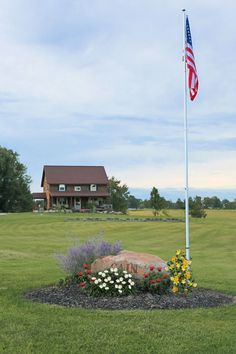 a flag pole in the middle of a flower bed