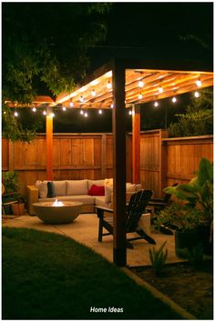 an outdoor living area lit up at night with string lights on the pergolated roof