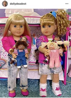 two dolls are sitting next to each other on a doll bed with clothes and accessories