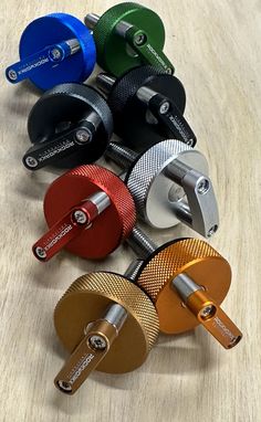 an assortment of different colored skate wheels on a wooden surface