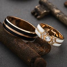 two wedding rings sitting next to each other on top of a piece of driftwood