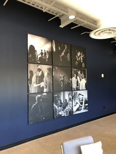 four black and white pictures hanging on the wall in an office building with chairs around them