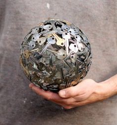 a person holding a metal ball with lots of keys on it