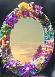 the mirror is decorated with mermaids and seahorses on it's sides