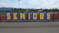 there is a sign made out of legos on the side of a fence that says seniors