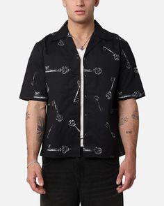 Cop the Skeleton Key Button Up Shirt so you can create some dope layered looks this season. This button up tee is lightweight and features some iconic graphic prints that are sure to raise your style from the dead. Get yours today. - Printed graphics - Full button-up close - Collared - Dropped shoulders - Short sleeves - Box fit - Colour: Black - Style: SMSKELEKEYSSBU Streetwear Short Sleeve Tops With Buttons, Short Sleeve Buttoned Tops For Streetwear, Short Sleeve Tops With Buttons For Streetwear, Urban Black Button-up Top, Black Camp Collar Top For Streetwear, Cotton Camp Shirt With Graphic Print For Streetwear, Casual Skull Print Shirt With Relaxed Fit, Casual Relaxed Fit Shirt With Skull Print, Casual Relaxed Fit Skull Print Shirt