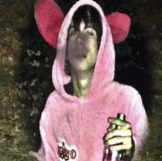 a man in a pink hoodie holding a beer