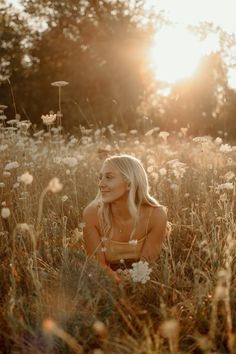 a woman sitting in the middle of a field