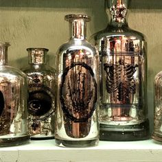 several glass vases sitting on top of a shelf