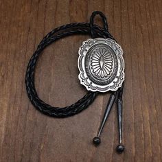 Vintage sterling silver bolo tie. The back of the bolo is stamped "Carson B." (Carson Blackgoat, Navajo). The bolo face is 2 5/8" tall by 2 1/8" wide. The design features fine stampwork and a domed center. The repousse diamond shape is a nice touch. The cord and tips are 38" long. The tips are guaranteed sterling silver. The bolo is in good condition with some natural patina. Navajo Nation, Bolo Tie, Diamond Shape, Indian Jewelry, Vintage Sterling Silver, Diamond Shapes, Design Features, Patina, Ghost