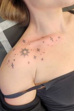 a woman with a tattoo on her chest is looking at the camera and has stars all over her shoulder