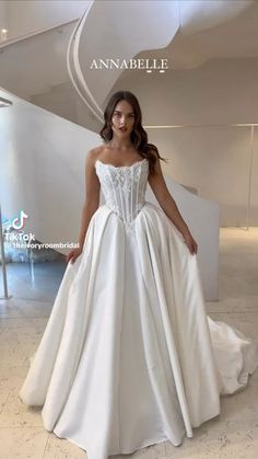 a woman in a white wedding dress posing for the camera