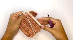 two hands are holding yarn and crocheting together to make a basket or purse