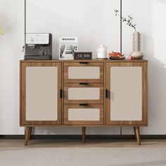 a wooden cabinet with two doors and three drawers on top, in front of a white wall