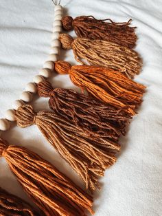 several tassels are laid out on a white sheet with beads and wood beads