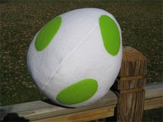 a white and green ball sitting on top of a wooden fence