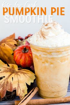 pumpkin pie smoothie in a glass with whipped cream on top and fall leaves around it