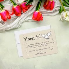 a thank card with red and white tulips next to it on a table