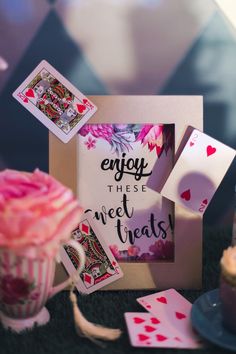 a table topped with cards and cupcakes next to a card game sign that says enjoy these sweet treats