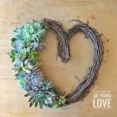 a heart shaped wreath with succulents on it