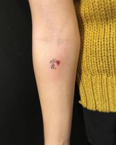 a woman's arm with a small tattoo on the left side of her arm