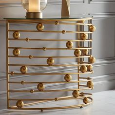 a gold sideboard with lots of balls on it and a candle in the middle