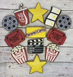 some cookies that are shaped to look like movie tickets and popcorn on a wooden table