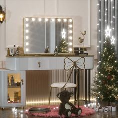 a teddy bear sitting on the floor in front of a vanity and christmas tree with lights