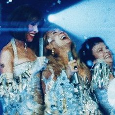 three women in sequins are laughing together