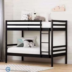 a black bunk bed sitting on top of a wooden floor next to a white rug