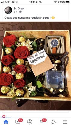 a wooden box filled with lots of red roses and chocolates next to a watch