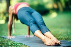 a woman is doing yoga outside in the grass with her hands on her hips and legs bent over her head