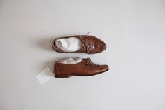 "Vintage 1980's soft brown leather men's oxfords with layered leather tops, leather soles, and low wooden heel. Made in Brazil by Giorgio Brutini. Perfectly broken in! Fits Like: 7.5/8 Wide | vintage label size 8 D Circa 1990s Fabrication: leather Condition: excellent Measurements: 10.25\" insole | 3.5\" ball" Vintage Wingtip Leather Shoes For Fall, Vintage Wingtip Dress Shoes For Fall, Vintage Oxfords With Textured Sole And Round Toe, Vintage Oxfords With Textured Sole, Vintage Leather Shoes With Stitched Sole For Spring, Brown Pointed Toe Oxfords With Rubber Sole, Vintage Wingtip Leather Shoes For Spring, Vintage Low-top Lace-up Shoes For Fall, Vintage Brown Lace-up Shoes With Brogue Detailing