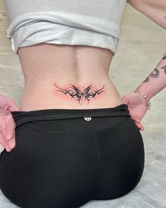 a woman's lower back tattoo with barbed wire