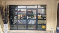 an open garage door with plants in the window and other items on the ground behind it