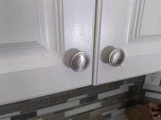 two white cupboards with knobs in a kitchen