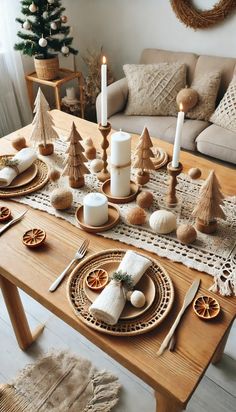 a wooden table topped with white candles and christmas decorations next to a couch in a living room