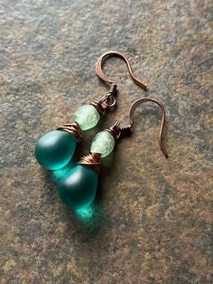 Matte Czech glass drops in a deep sea teal, topped with small green recycled African glass beads and wrapped in lightly oxidized copper wire with genuine copper ear wires. These high-quality Czech glass beads look like sea glass, with perfect color and shape, and they cast a glow in the light. Inspired by the captivating hues of the deepest green seas. Teal Czech glass teardrop earrings, copper earrings, rustic copper jewelry, sea glass earrings, sea glass jewelry, frosted glass jewelry, beach jewelry, unique earrings, gift for women, wire wrapped jewelry, wire wrapped earrings, oxidized copper, oxidized jewelry, African glass Teal Earrings, Hippie Chick, Jewelry Beach, Wrapped Earrings, Oxidized Copper, Sea Glass Earrings, Wrap Jewelry, Wire Work Jewelry, Jewelry Wire