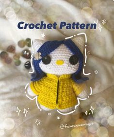 a crocheted kitty doll with blue hair wearing a yellow sweater and black eye glasses