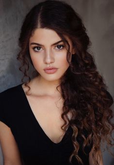 a beautiful young woman with long curly hair