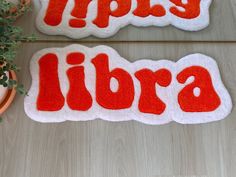 two bath mats with the words naps and libra written in red on them