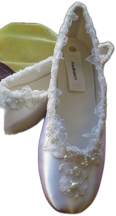 a pair of white shoes with pearls on them