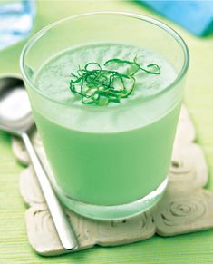 a green drink sitting on top of a table